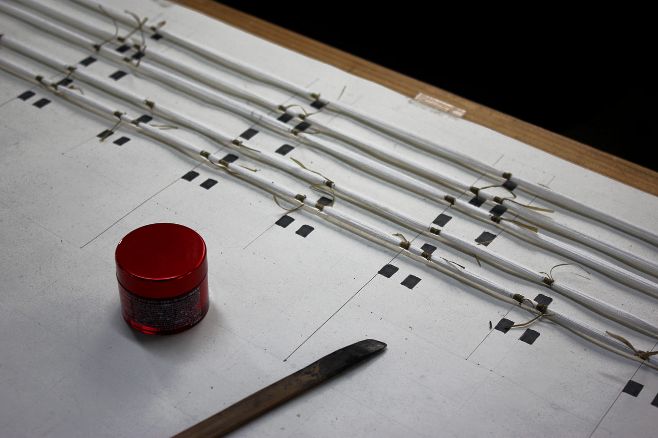 Les fils sont tendus au-dessus du dessin afin de copier l'emplacement du motif.