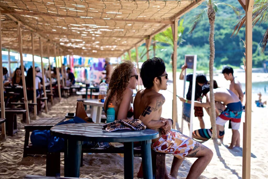 personnes tatouées sur une plage au Japon