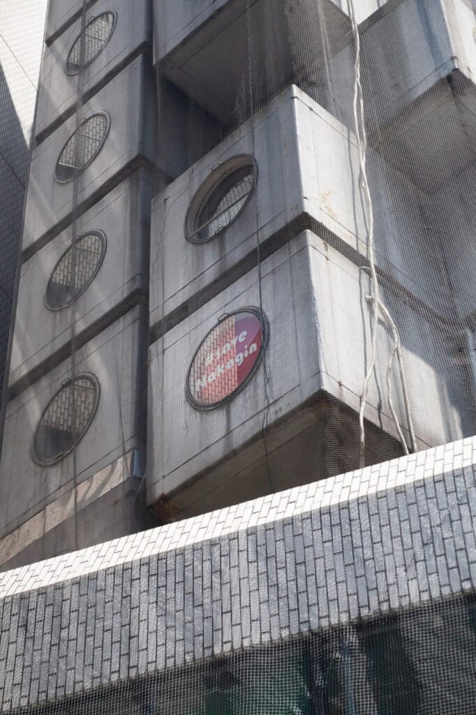 Fenêtre avec un panneau disant "save Nakagin"