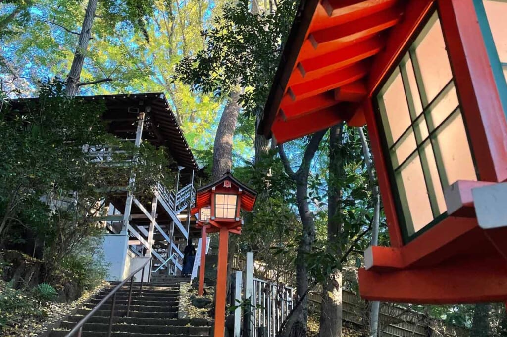 Marches menant à un temple japonais, bordées de lanternes vermillon