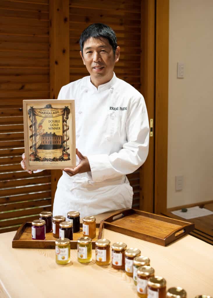 Gérant d'une ferme japonaise montrant ses confitures primées