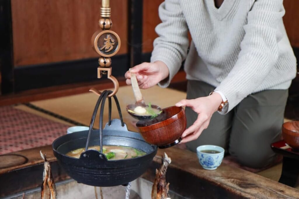 Une personne se servant un bol de nabe dans un ryokan au Japon