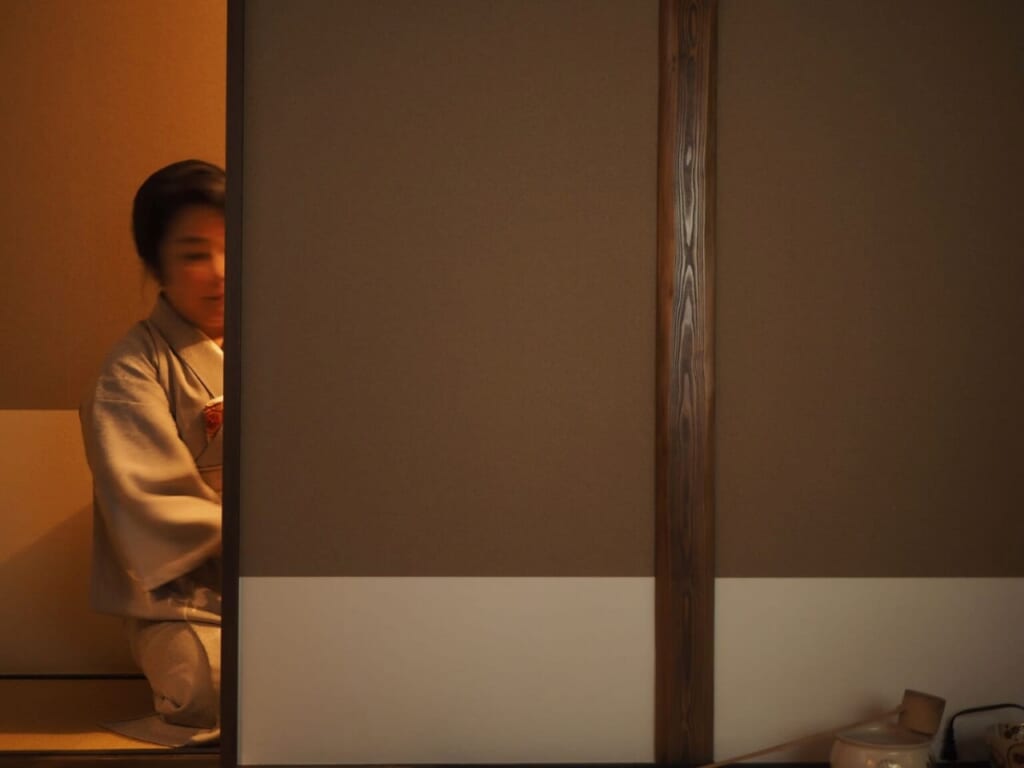 dame en kimono derrière portes coulissantes