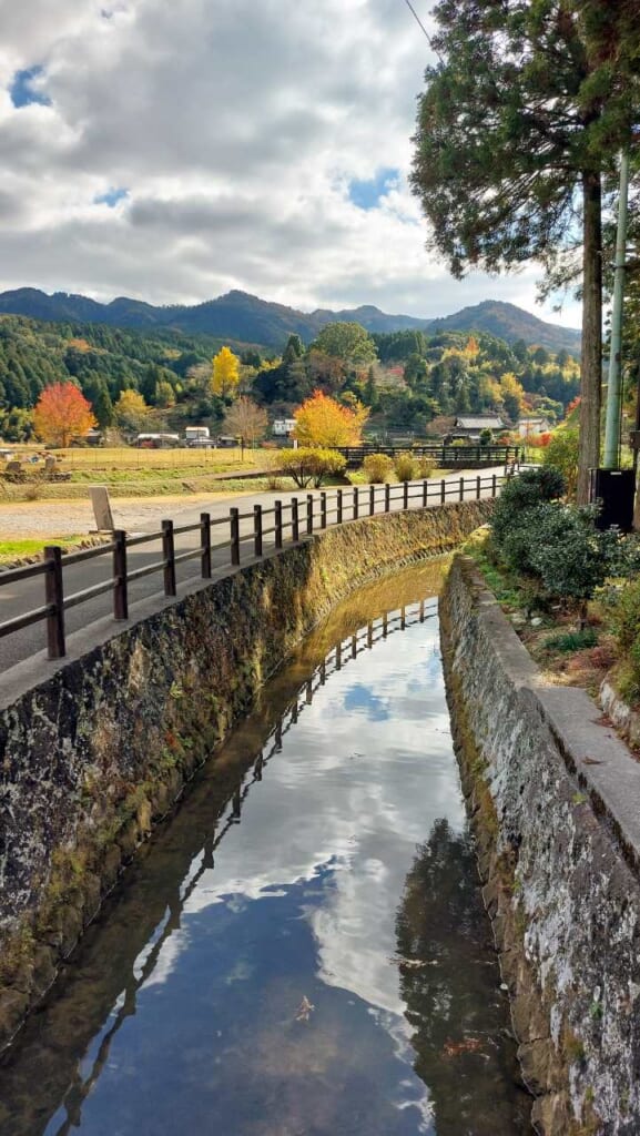 Paysage japonais avec un canal de pierres et des montagnes en arrière plan