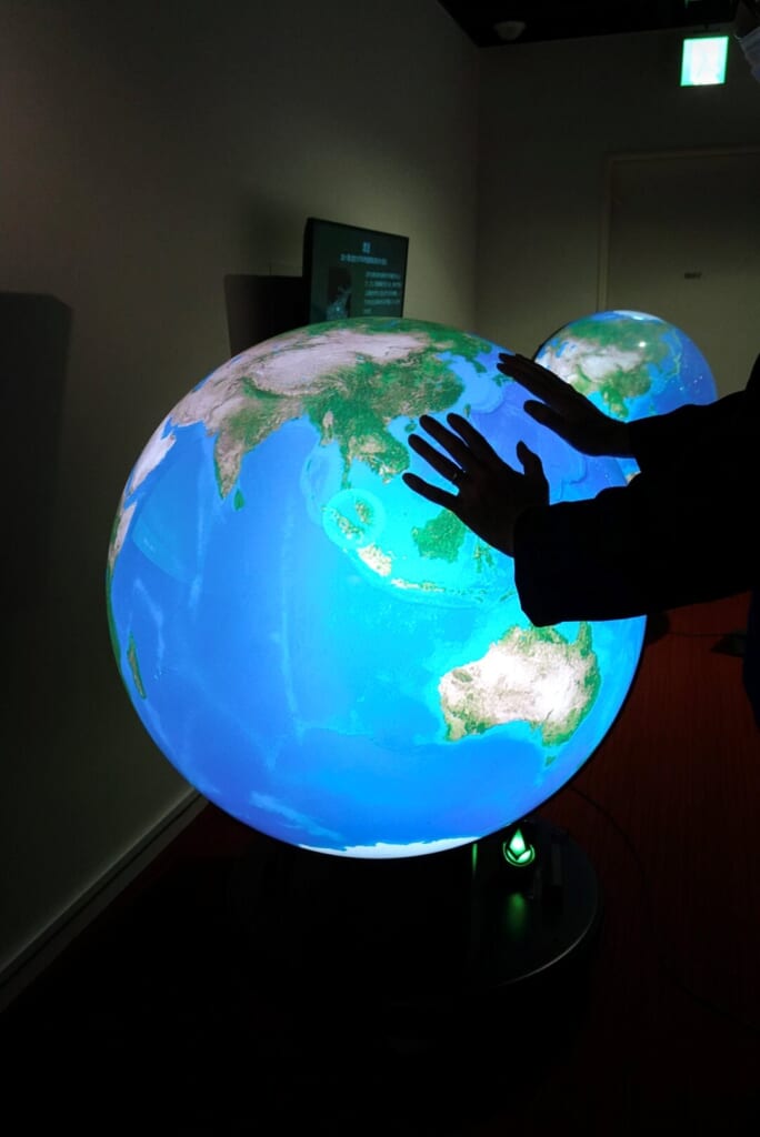 globe terrestre et mains posées dessus