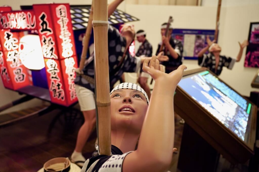 modèle d'un enfant tenant le pôle en bambou d'un kanto en équilibre sur l'épaule