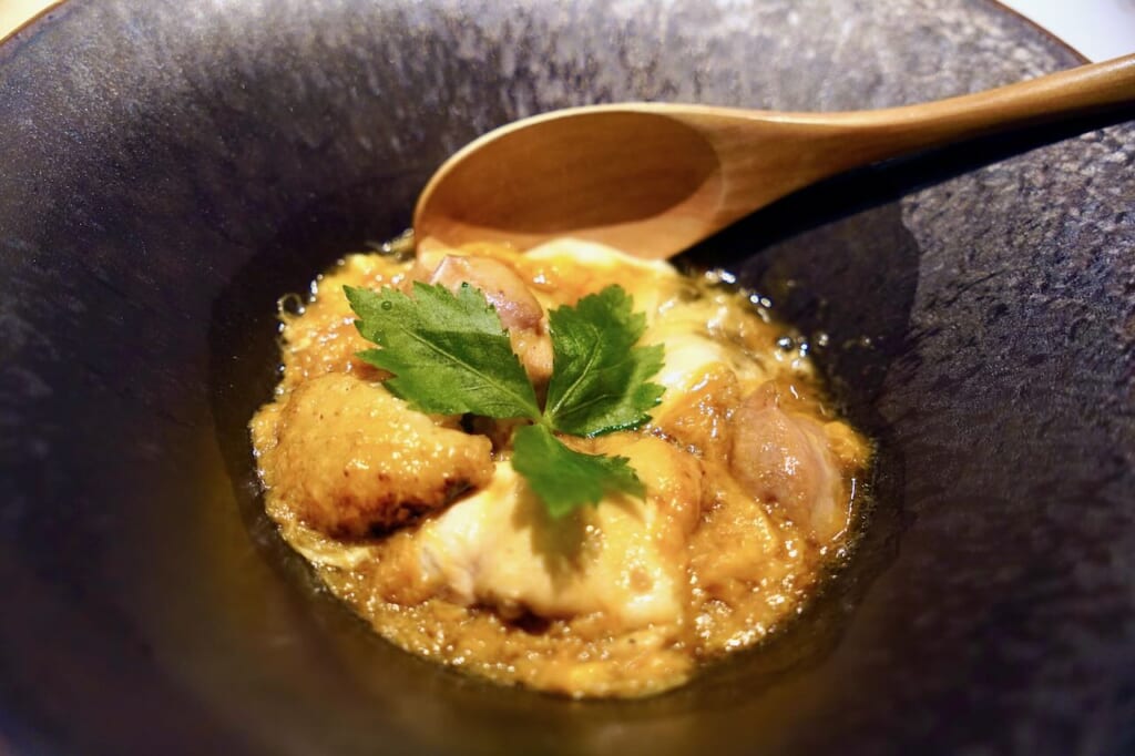 oyakodon avec poulet hinai-jidori servi dans une assiette noire