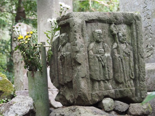 Roca esculpida y ramo de flores en Kumano Magaibutsu (Kunisaki, Oita)