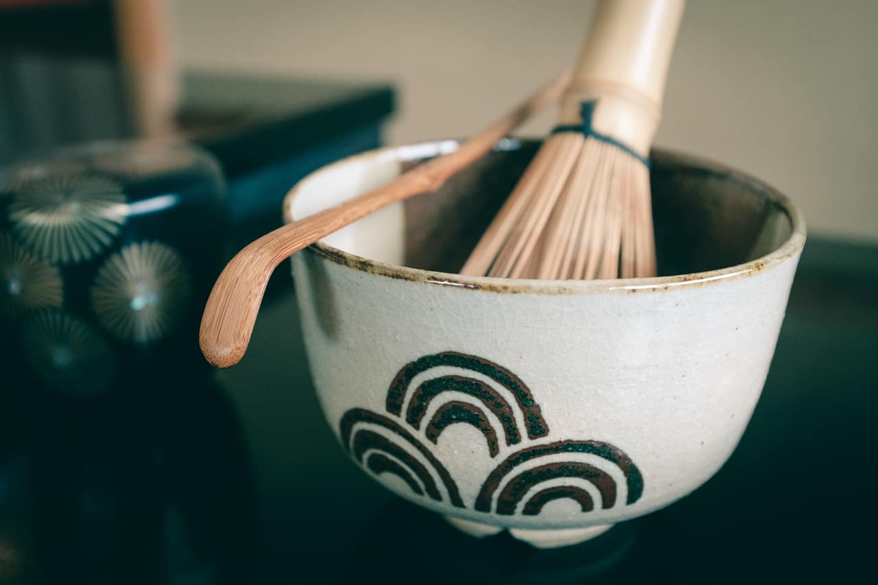 Una taza de té con el batidor del bambú