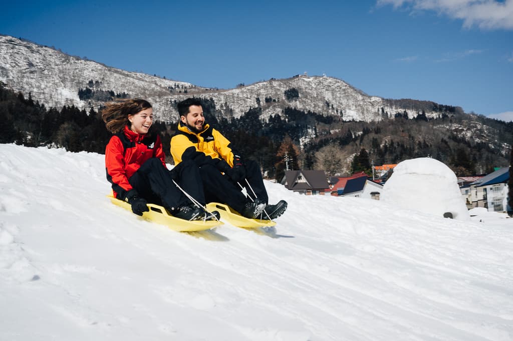 Hernán y Maria bajando con el trineo en el pueblo de los ilgús