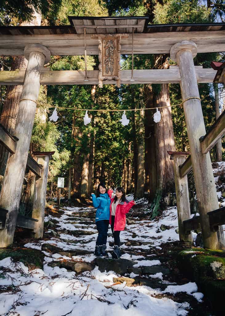 Nuestras compañeras delante de el gran torii entre la nieve en la entrada del santuario Kosuge,