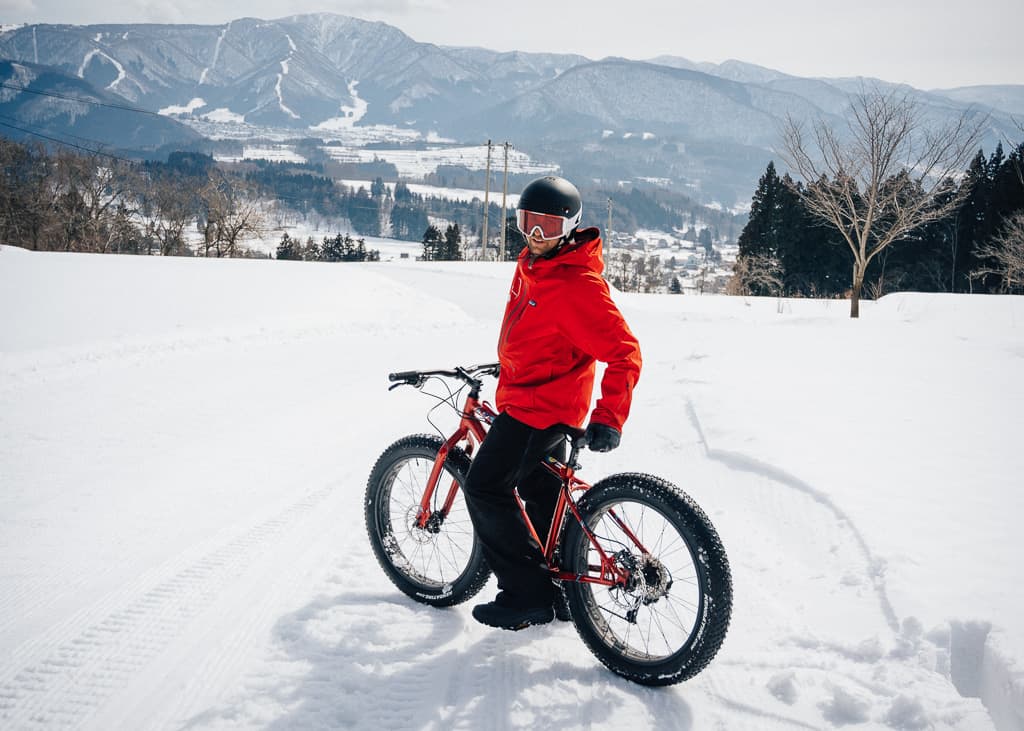 Uno de nuestros compañeros de snow cycling a punto de bajar la bajada con las bicis de nieve