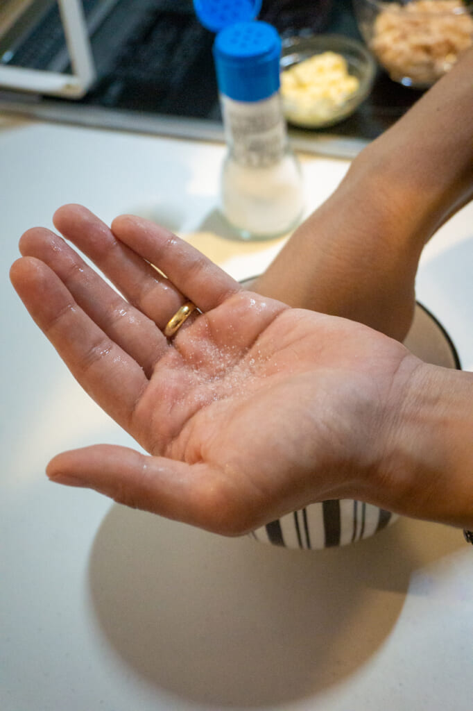 Añadiendo la sal y el agua en la palma de la mano