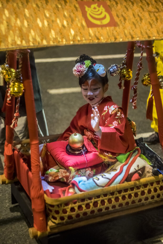 Una joven zorro a bordo de un pequeño palanquin durante el Kitsune no Gyoretsu