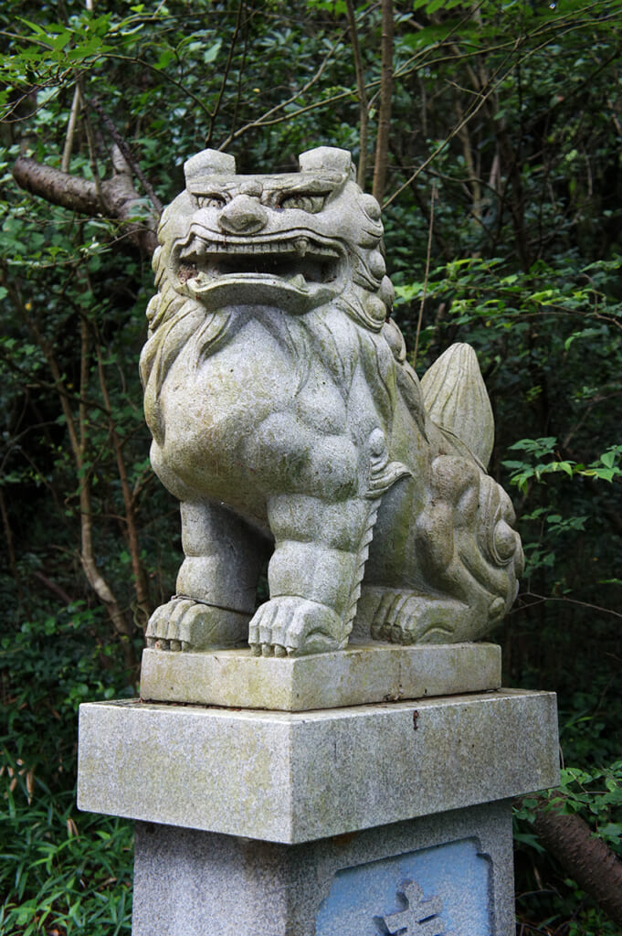Un perro en la entrada del hachiman jinja en Manabeshima