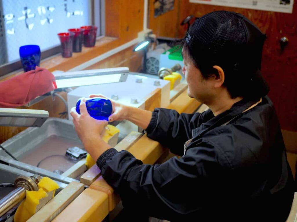 Un artesano mostrando cómo realizar los patrones en el vaso 