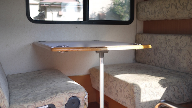 Una mesa con sus sofás dentro de la caravana