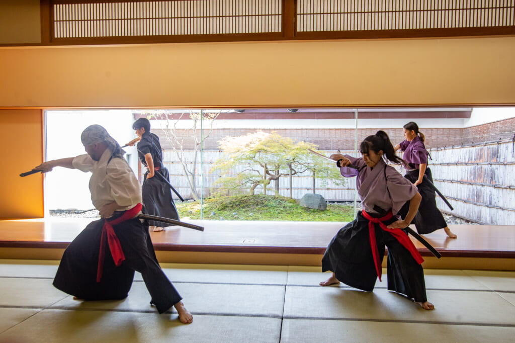cuatro personas haciendo una coreografía con espadas