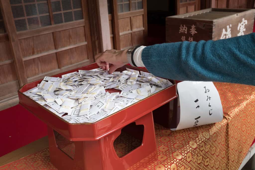 sacando un omikuji para el año nuevo
