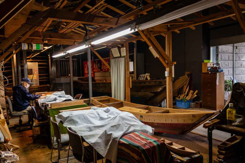 hombre trabajando en tienda con barcos de pesca japoneses en japón