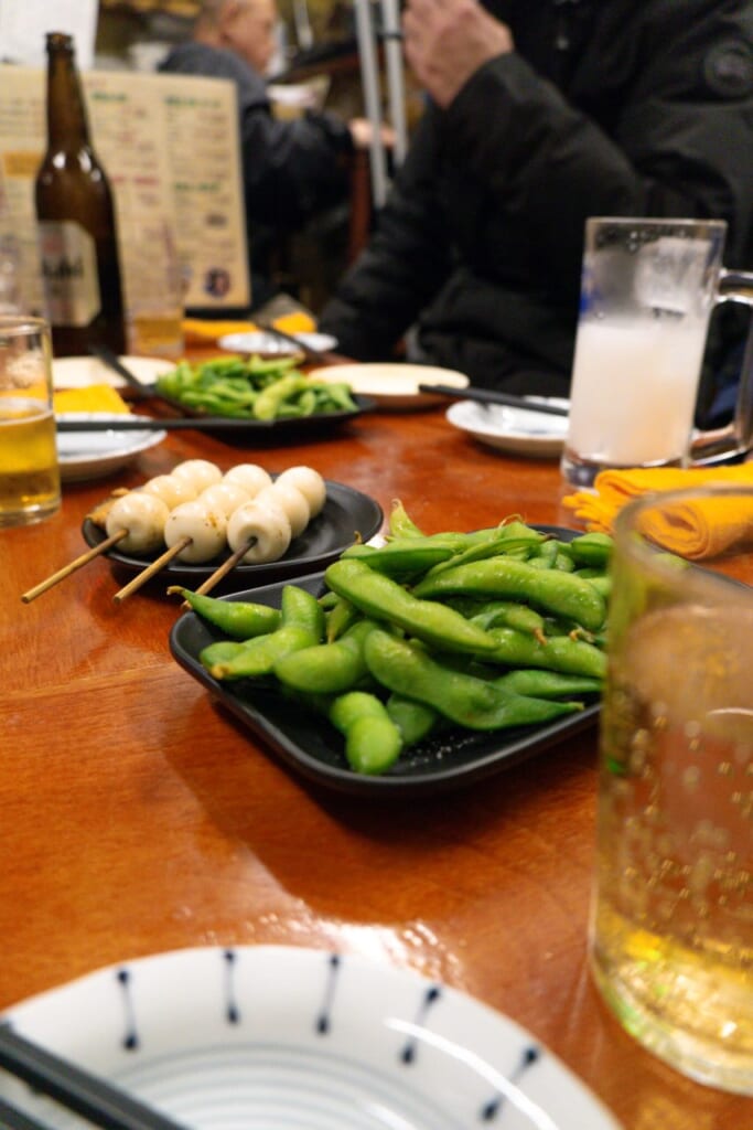 Edamame y brochetas en un izakaya japonés