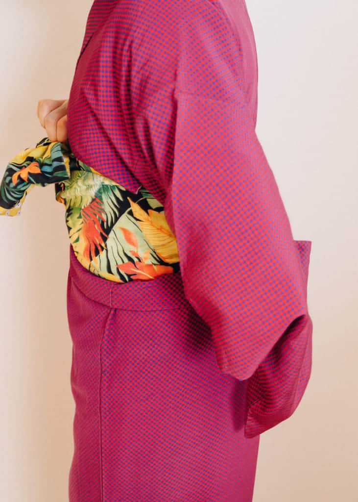 Dreht die Schleife nach hinten auf die Mitte eures Rückens.