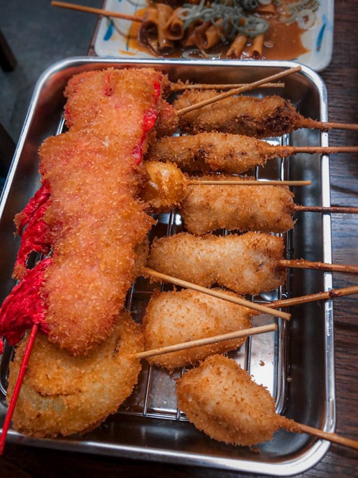 Probiert die lokalen Spezialitäten von Shinsekai, Kushikatsu und Fugu.