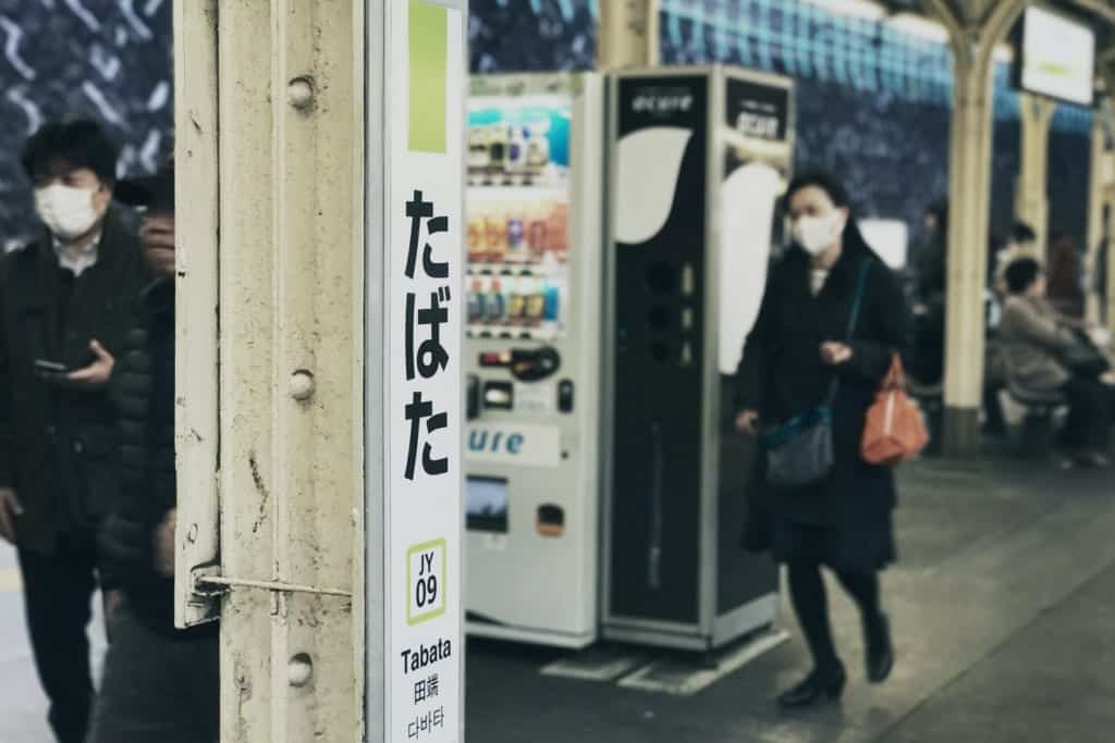 Japaner, die in der Öffentlichkeit Masken tragen.