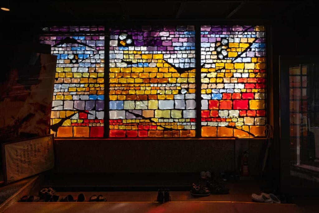 Buntglas erhellt das Innere des Enoshima Daishi Tempels.