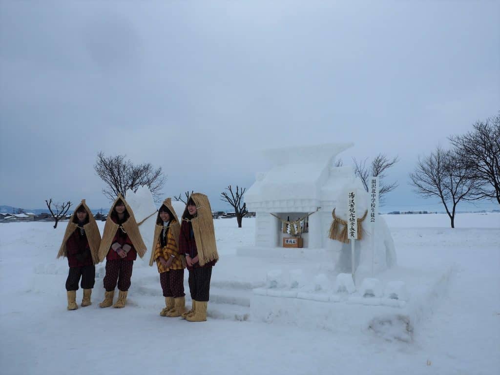 Mädchen vor einem Schrein aus Schnee.