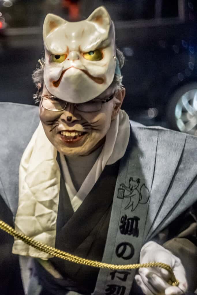 Eine Besucherin auf dem Kitsune no Gyoretsu Fest mit einer Fuchsmaske.