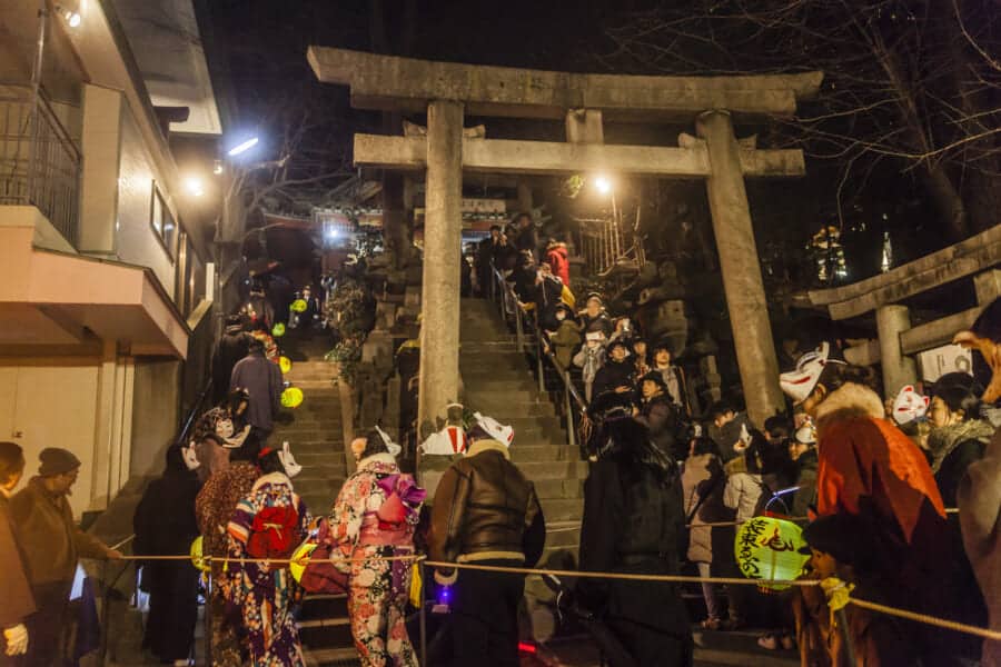 Die Teilnehmer gehen die Treppen am Oji Inari Jinja-Schrein rauf.