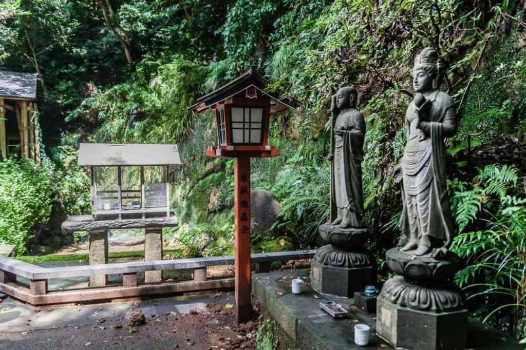 Statuen vor dem Wasserfall im Todoroki-Tal.